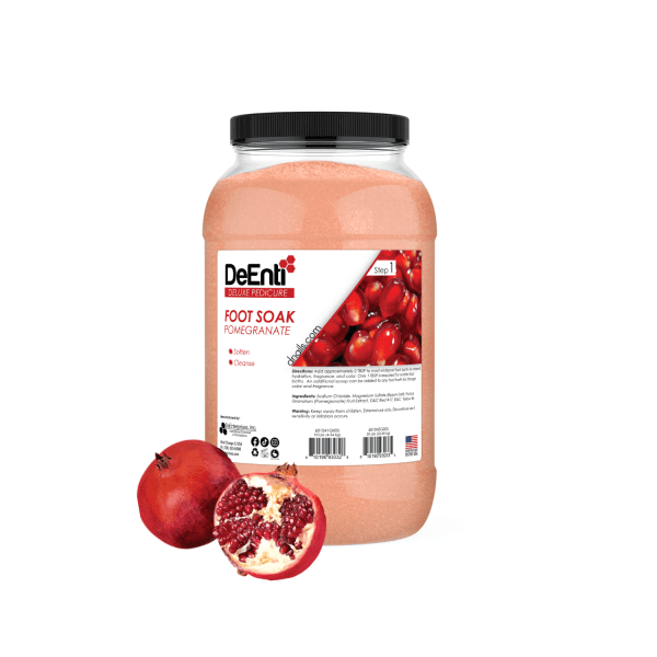 A 10 lbs professional jar of DeEnti Pomegranate Foot Soak, with rich red bath salt crystals and a fresh, open pomegranate next to it.