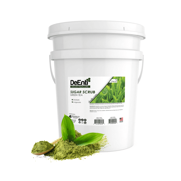 5-gallon white pail of DeEnti Green Tea Sugar Scrub for professional pedicures, shown with a scoop of green tea powder and fresh leaves in the foreground.